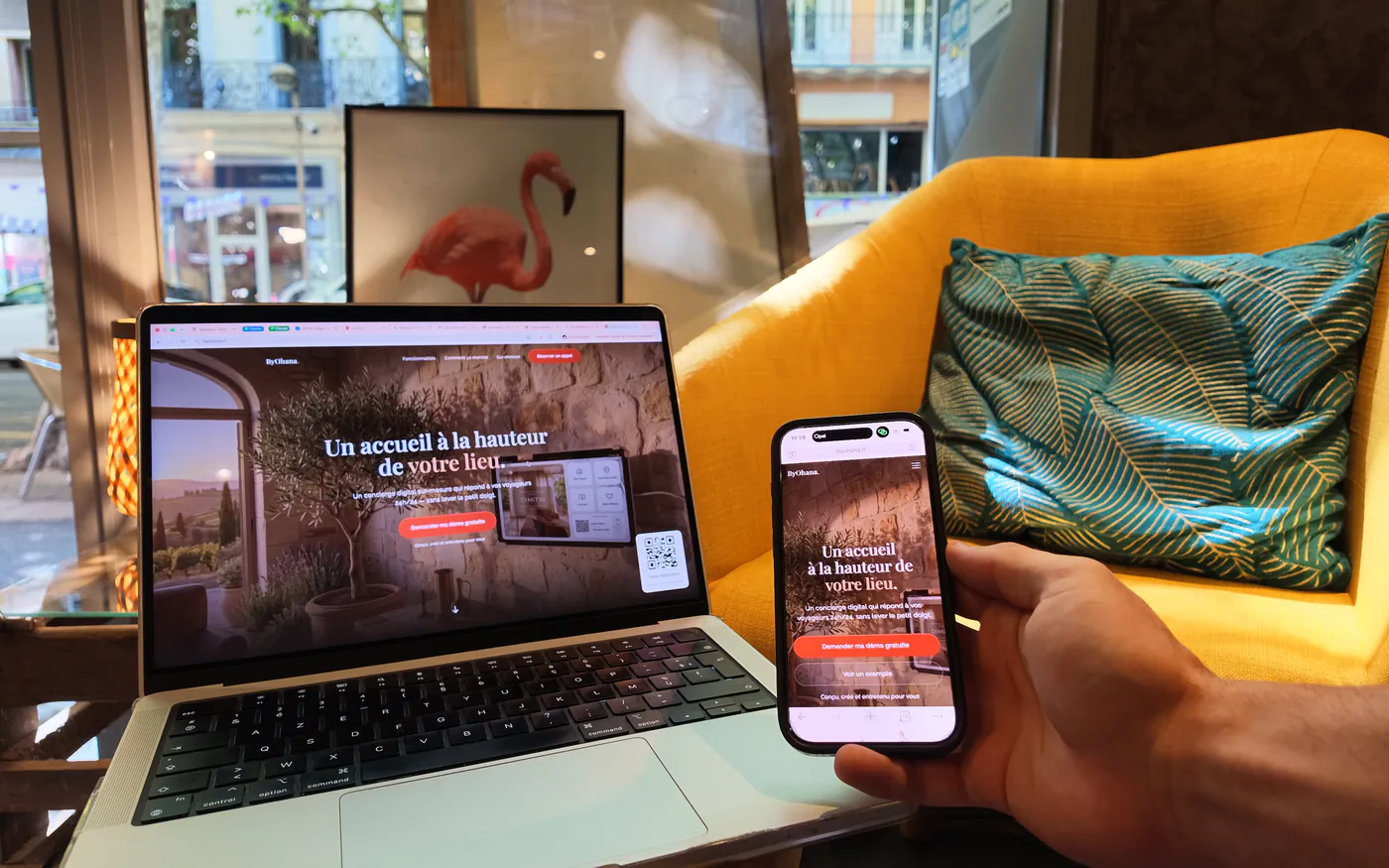 Site sur-mesure ByOhana affiché sur ordinateur portable et sur téléphone, tenu en main dans un café